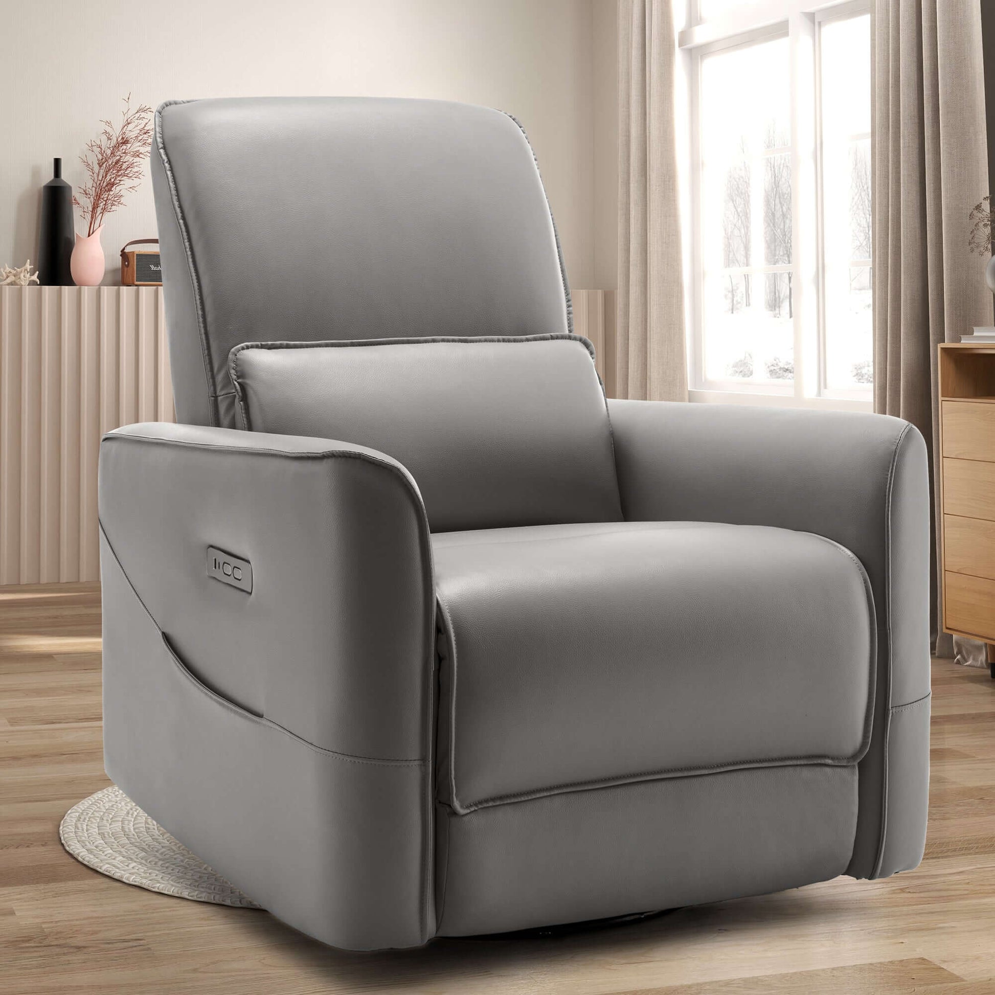 Swivel recliner chair in faux leather, designed for comfort with electric rocking feature and side pockets.